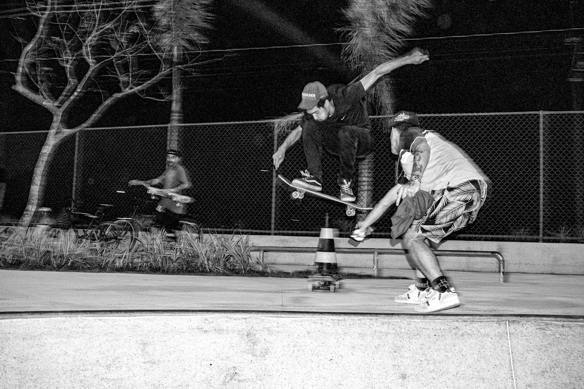 Two skateboarders performing tricks at night